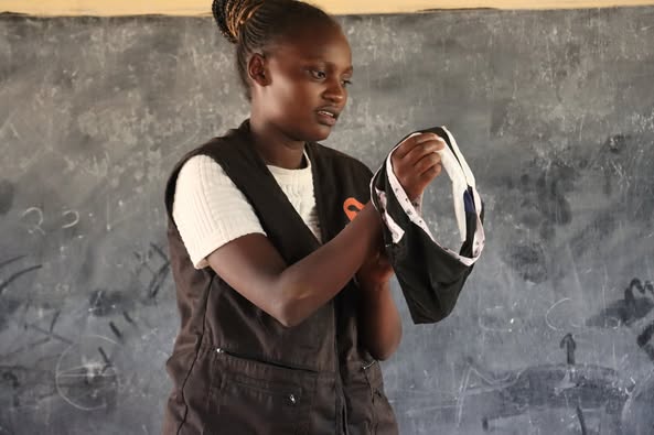 An Entepesi Kenya facilitator demonstrating menstrual hygiene management in a classroom