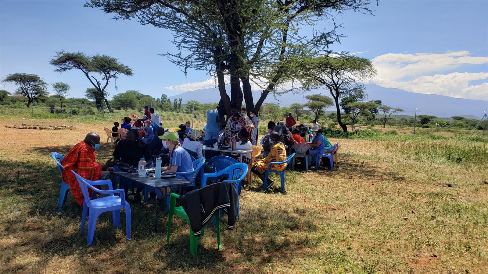 An Entepesi Kenya team meeting with a community under an acacia tree