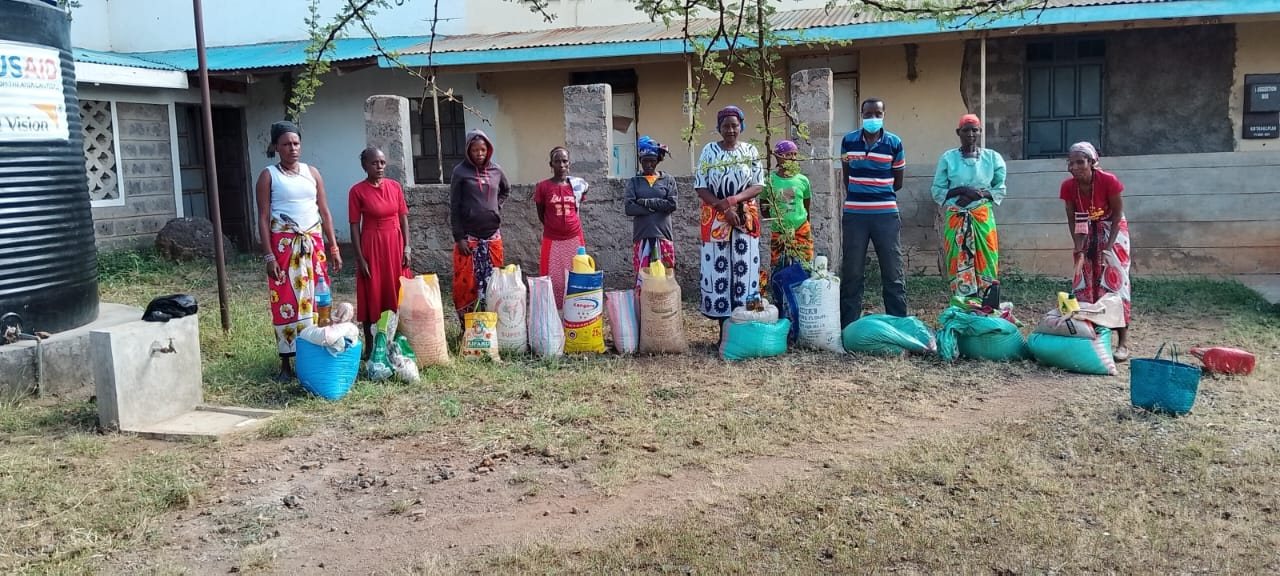 Community members waiting with water containers outside a rural health facility