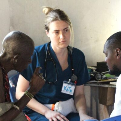 A volunteer clinician listens to a patient during a consultation